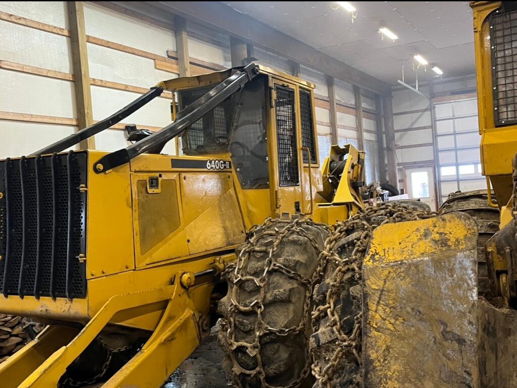 a yellow colored used cable skidder parked in garage