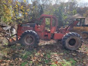 a red forestry machine working in field 