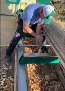 Buyer performing a test cut on a used portable band sawmill before purchasing.
