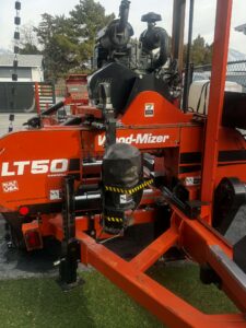 Portable band sawmill cutting logs at a small sawmill business
