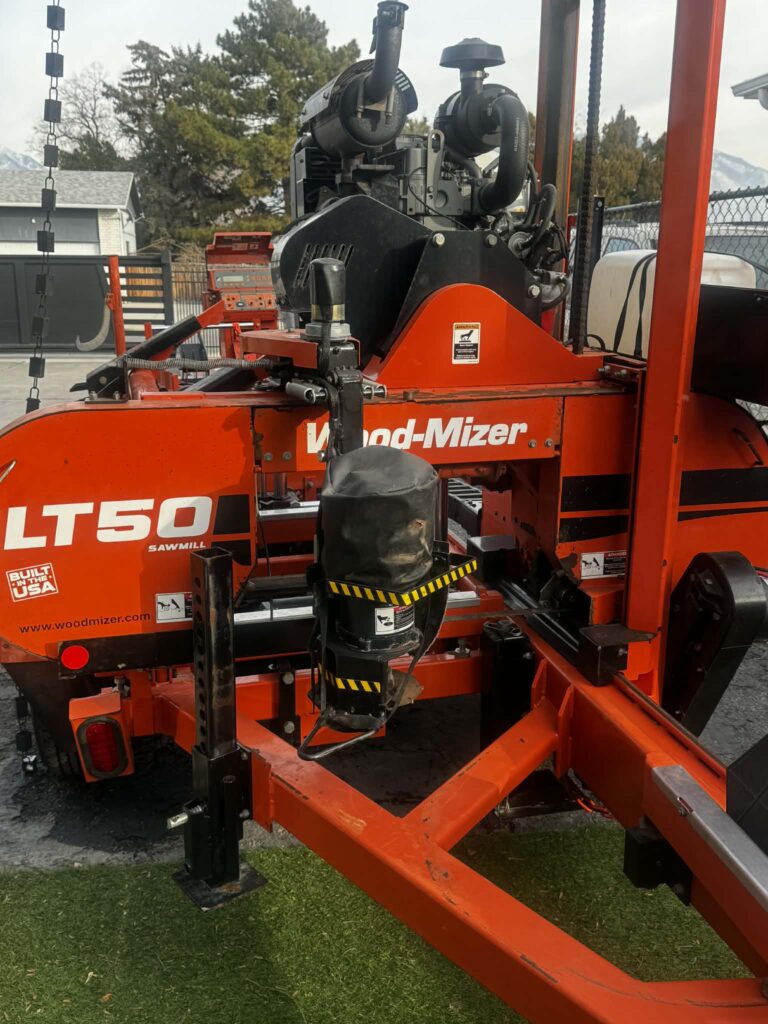 Portable band sawmill cutting logs at a small sawmill business